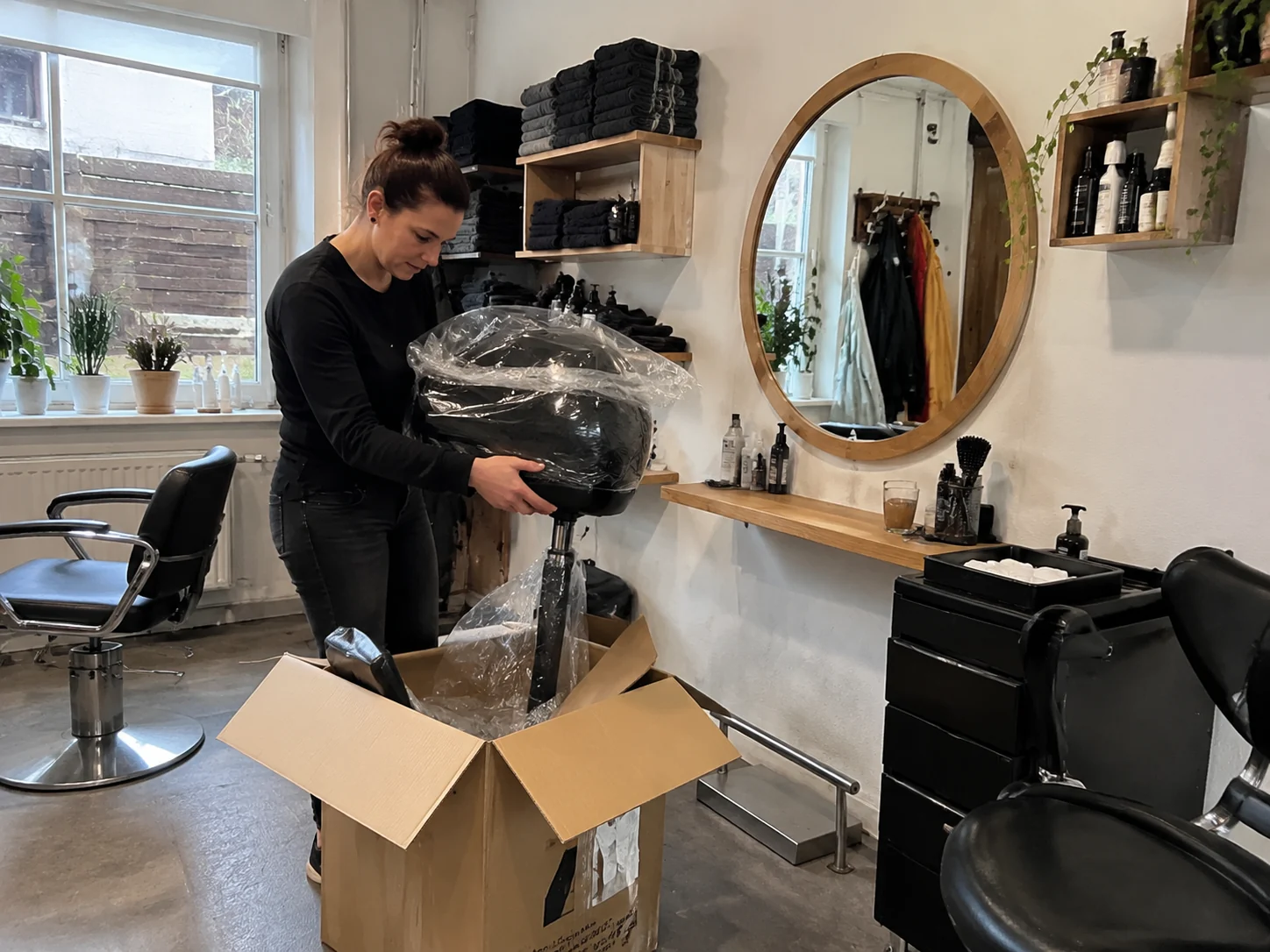 Inhaberin eines Friseursalons packt einen neuen Waschplatz aus